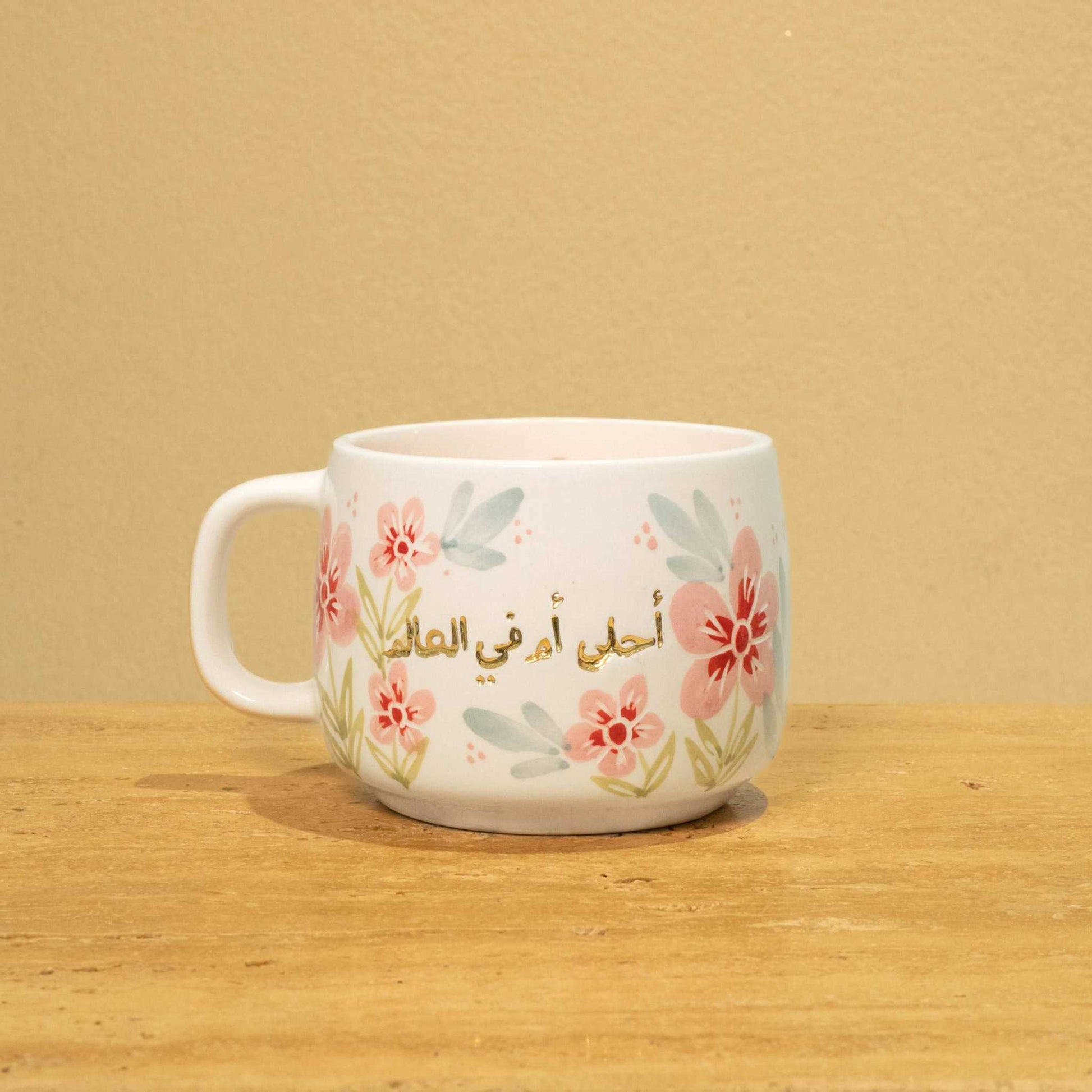 Best Mother In The World Ceramic mug with gold Arabic monogram and floral design.
