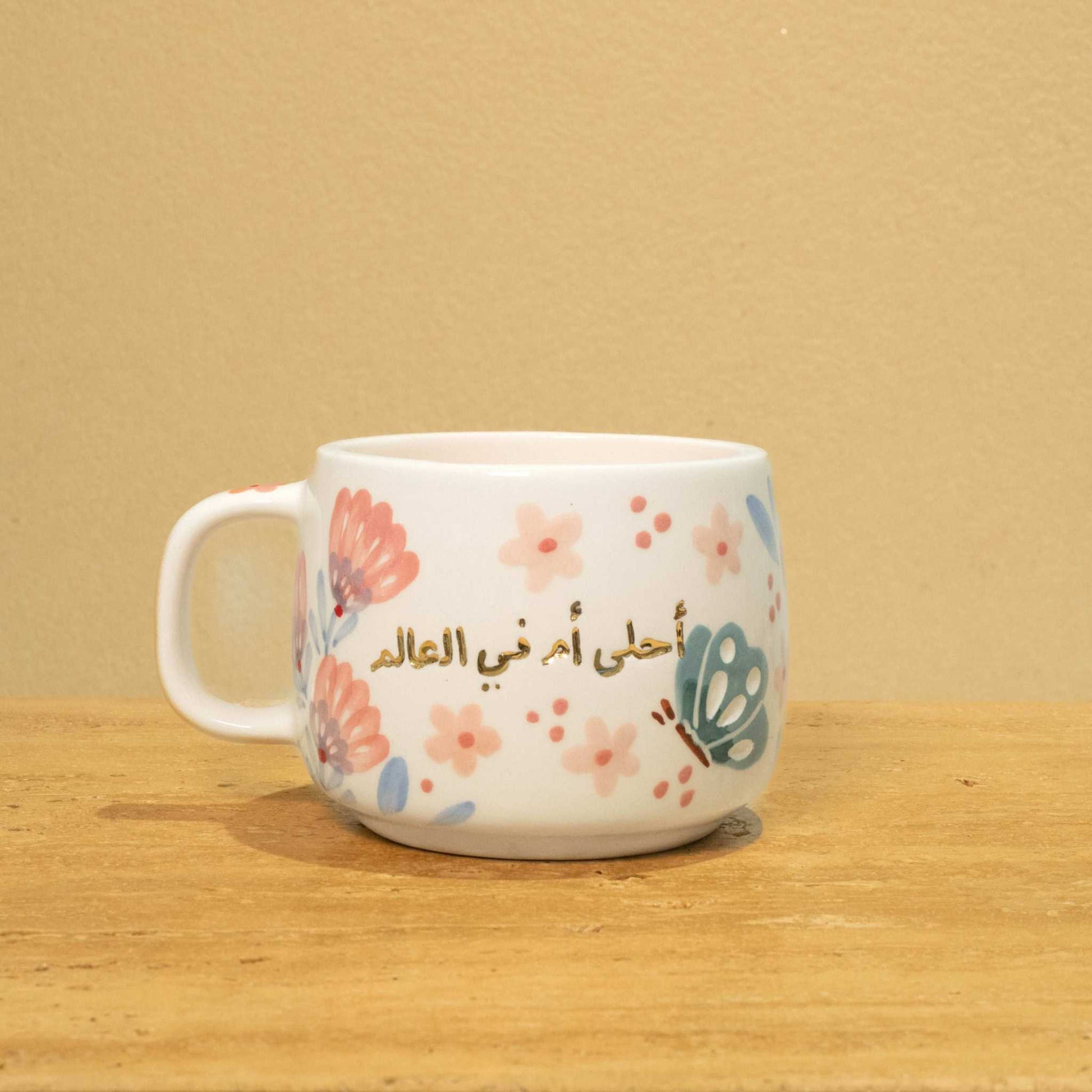 Best Mother In The World Ceramic mug with gold Arabic monogram and floral design.