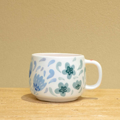 Personalized gold monogram ceramic mug with floral design.