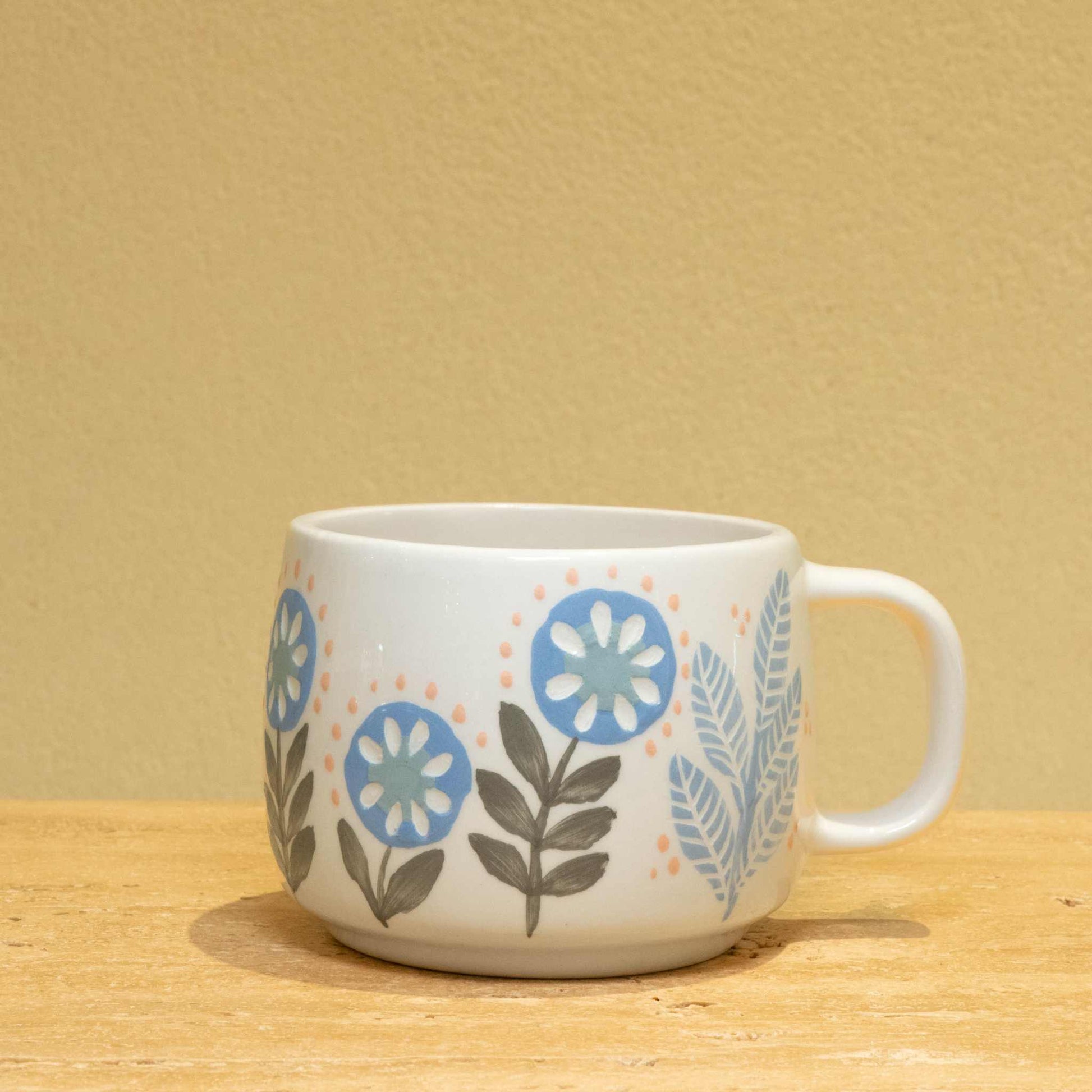 Personalized gold monogram ceramic mug with floral design, featuring "BEST BROTHER" inscription.