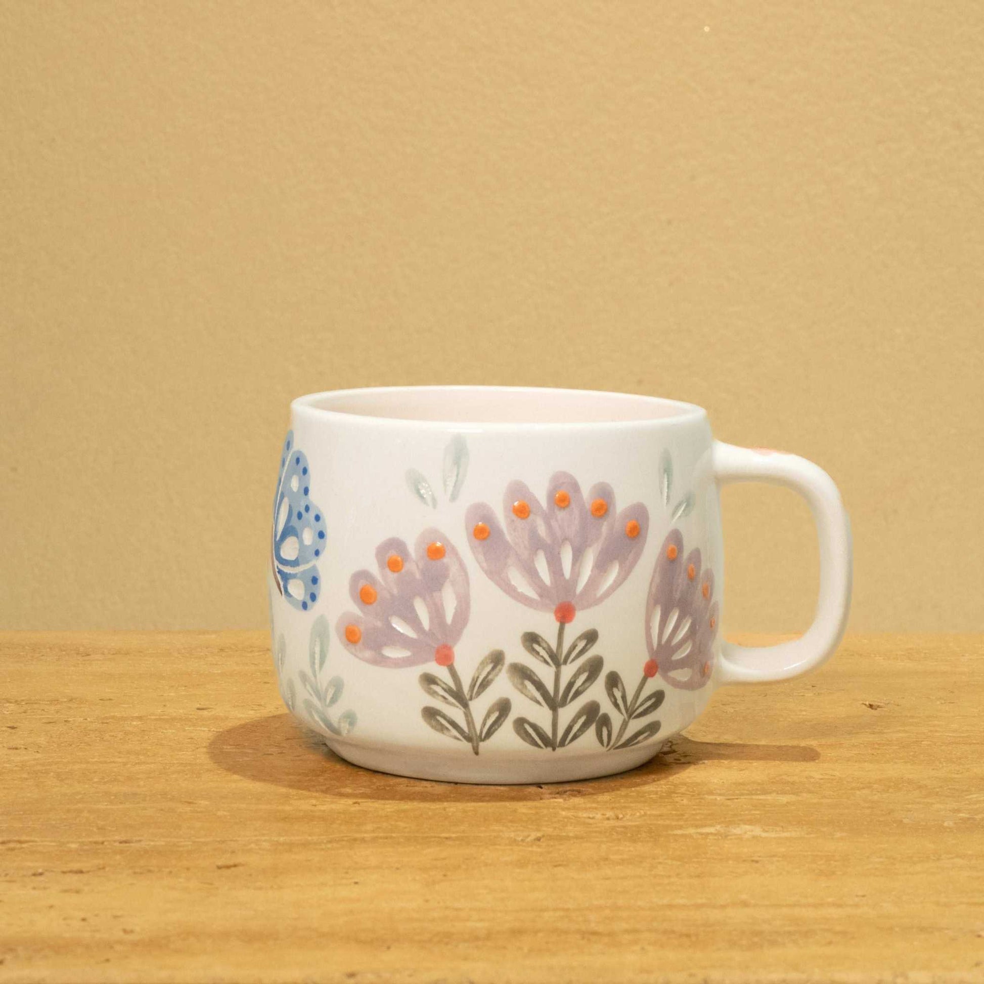 Personalized gold Arabic monogram ceramic mug with floral design for "Best Sister in the World."