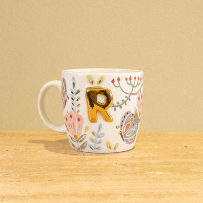 Custom handmade ceramic mug with gold-plated initial "R" and floral design.