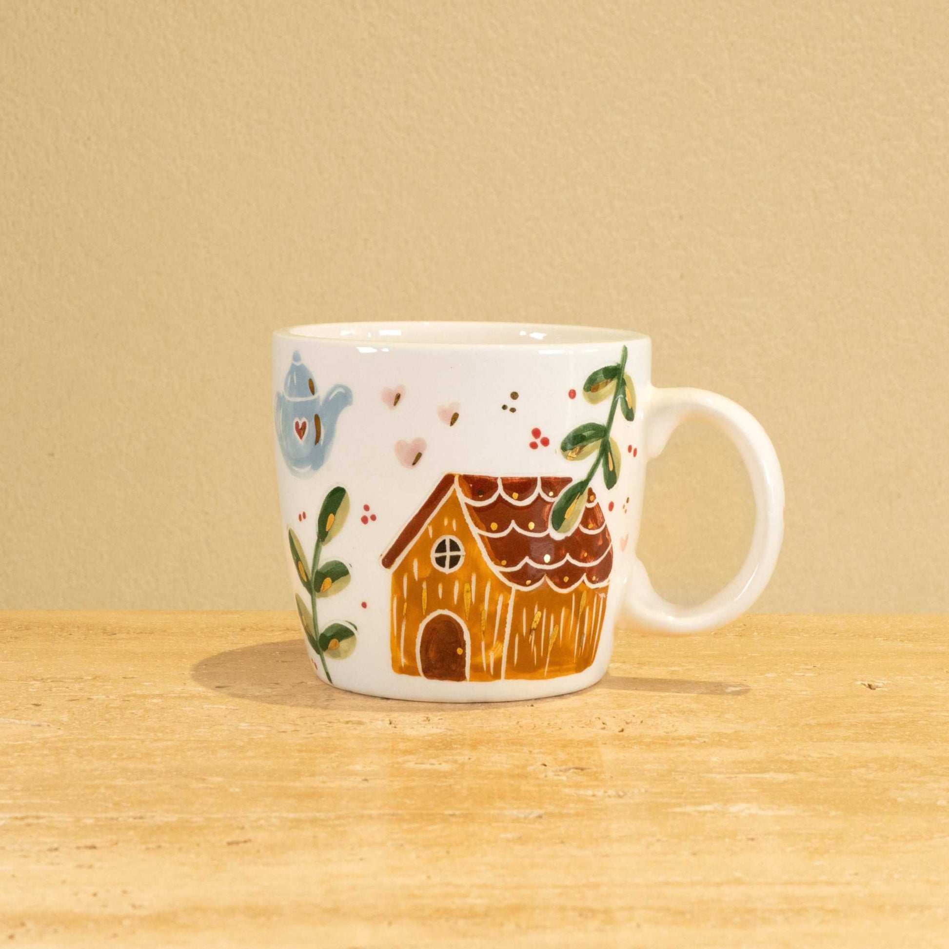 Custom handmade ceramic mug with gold-plated initial "R" and floral design.