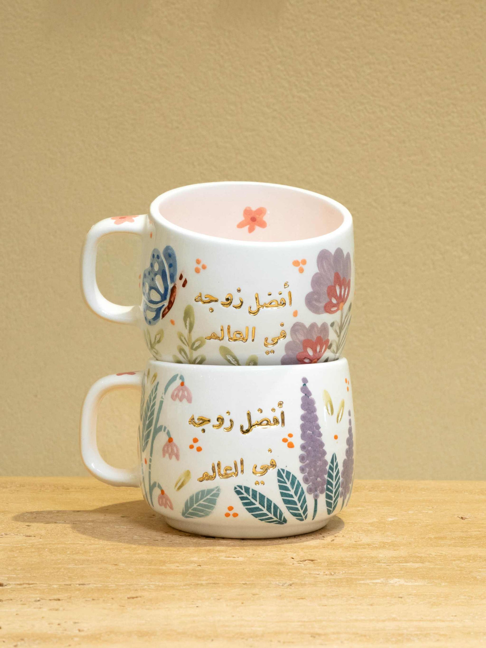 Personalized gold Arabic monogram ceramic mug with floral design.