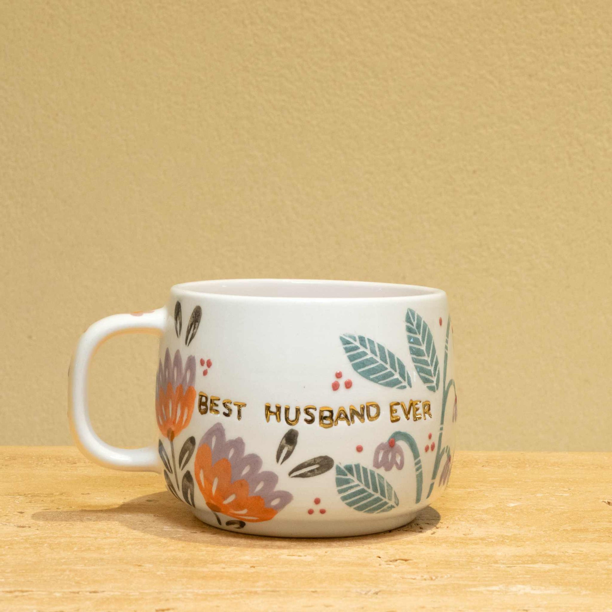 Personalized gold monogram ceramic mug with "Best Husband Ever" and floral design.