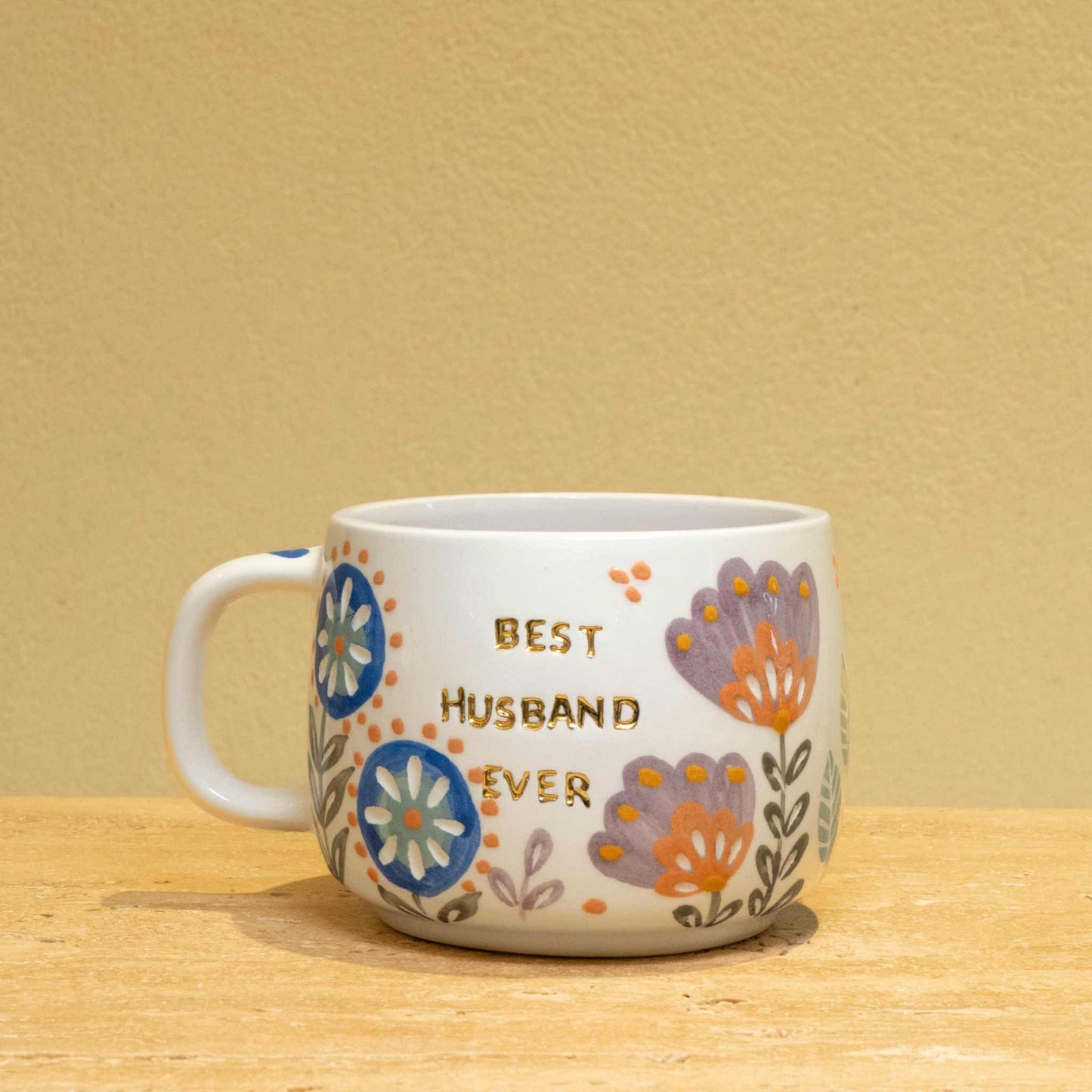 Personalized ceramic mug with gold "Best Husband Ever" text and floral design.