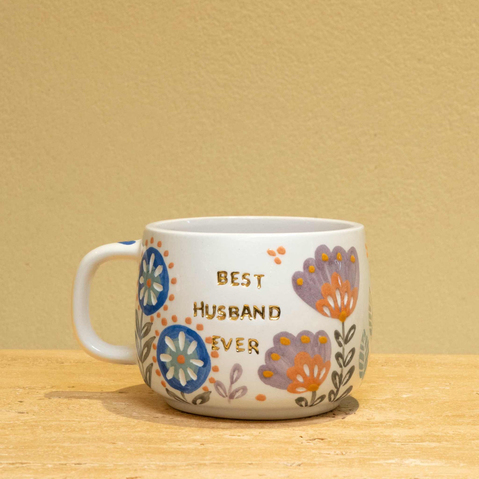 Personalized ceramic mug with gold "Best Husband Ever" text and floral design.