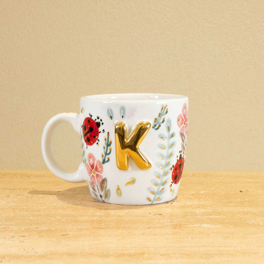 Custom handmade ceramic mug with gold-plated initial "K" and floral design.