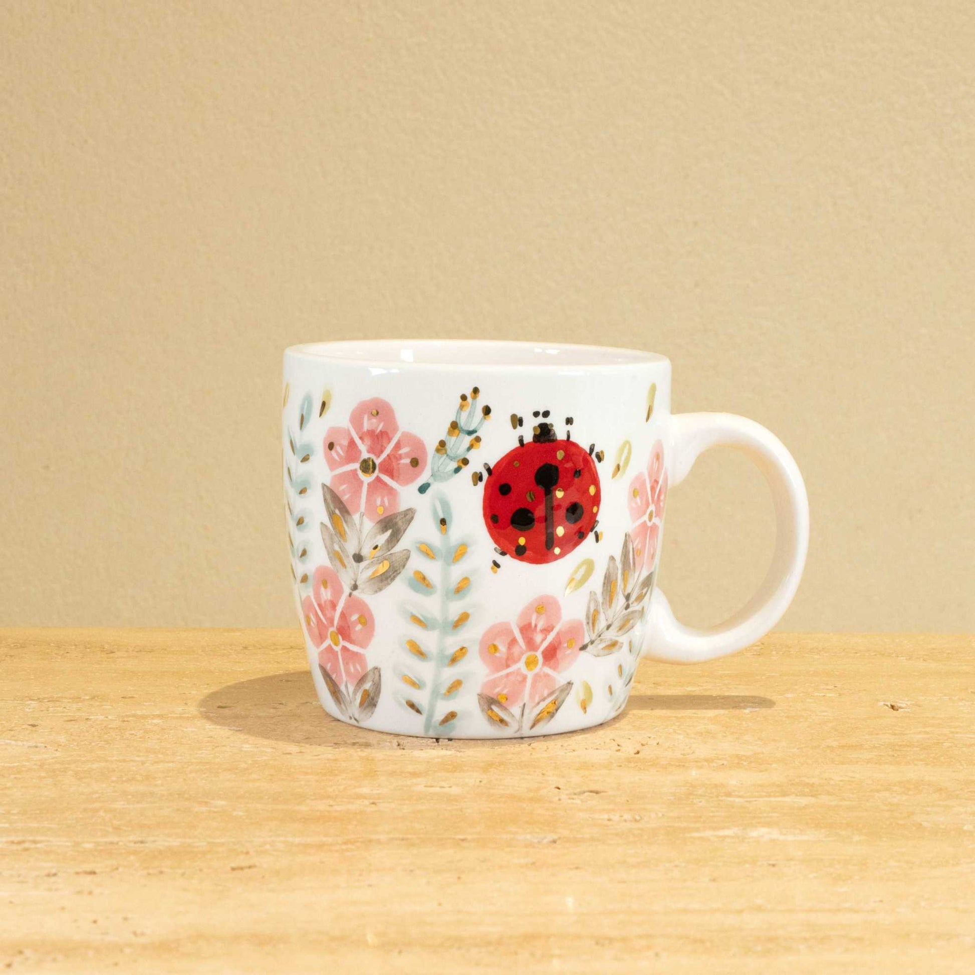 Custom handmade ceramic mug with gold-plated initial "K" and unique floral design.