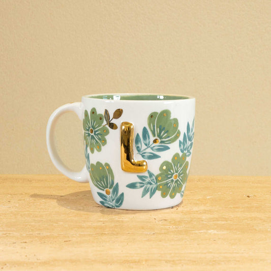 Custom handmade ceramic mug with gold-plated initial "L" and floral design.
