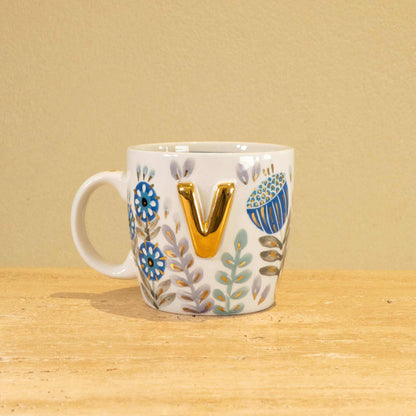Custom handmade ceramic mug with gold-plated initial "V" and floral design.
