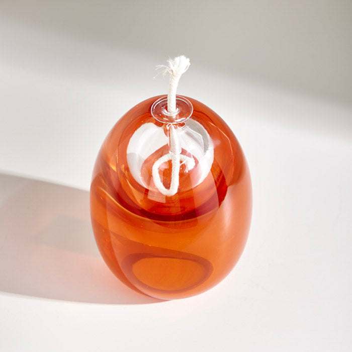 Small Egg shape oil lamp in coral orange, elegant design, cozy ambiance.