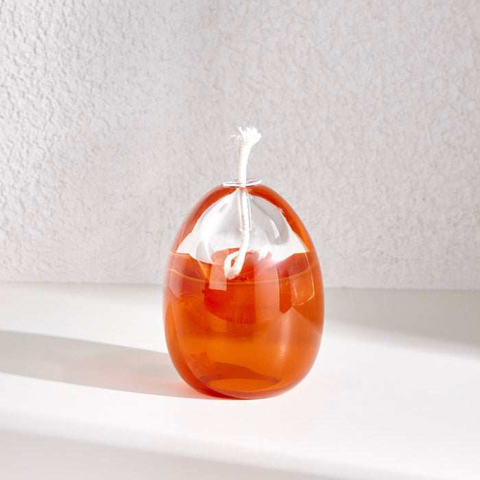 Small Egg shape oil lamp in coral orange, elegant design, cozy ambiance.