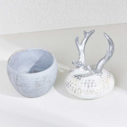 Silver deer horn decoration with a weathered base and antler lid.
