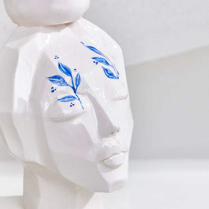 CERAMIC HAND MADE girl face candle holder with artistic blue leaf design.
