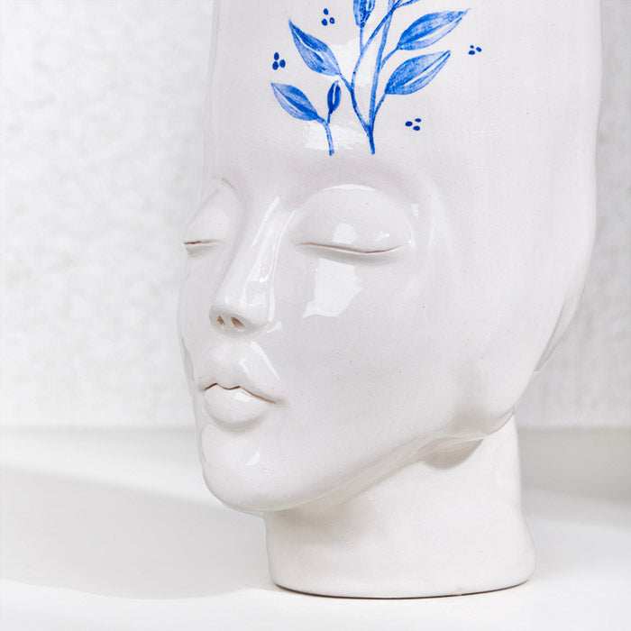 Ceramic handmade girl face pot with blue floral design, perfect for plants and home decor.