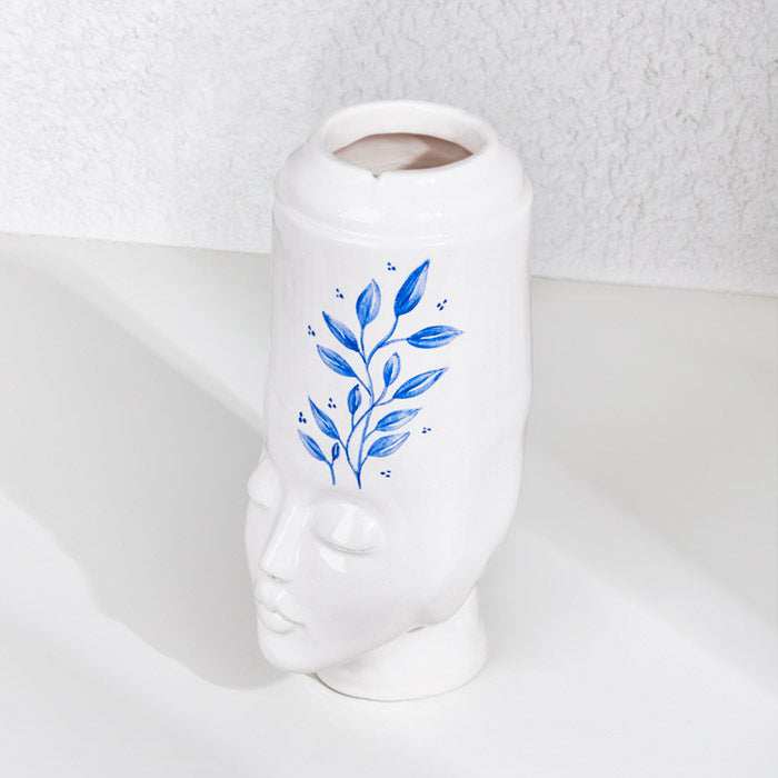 ceramic handmade girl face pot with blue leaf design