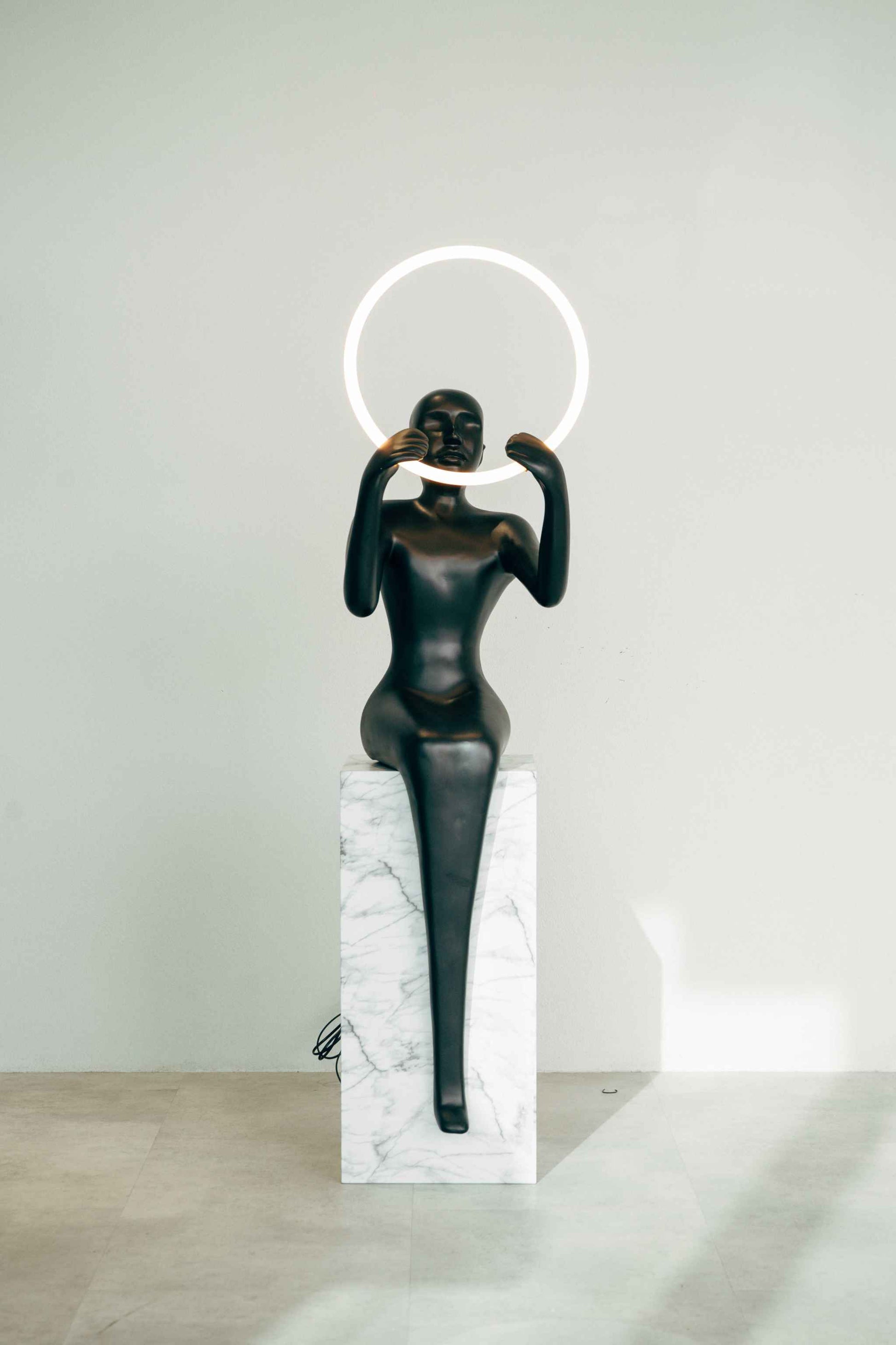 Meditation Sculptural Floor Lamp - BlackElevate your space with this stunning modern sculpture that doubles as functional lighting. Featuring a sleek, black seated human figure holding a glowing LED ring, Floor Lamp