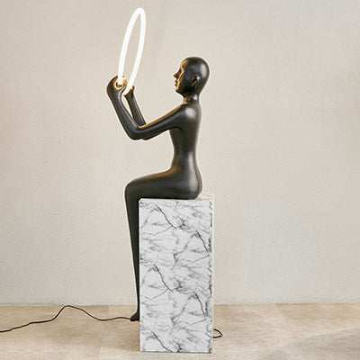Meditation Sculptural Floor Lamp - BlackElevate your space with this stunning modern sculpture that doubles as functional lighting. Featuring a sleek, black seated human figure holding a glowing LED ring, Floor Lamp