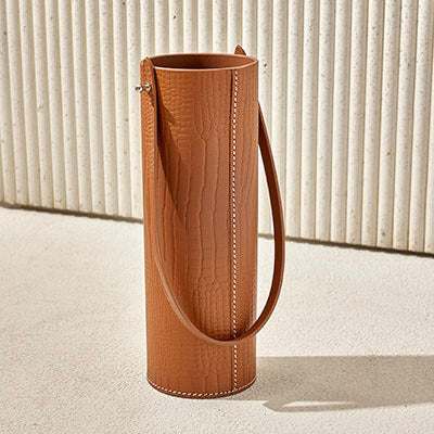 Cylinder bottle holder leather with crocodile-embossed texture and strap.