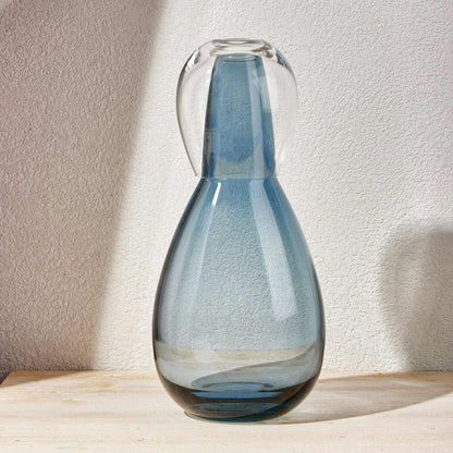 Steel blue night water set with a hand-blown glass carafe and matching tumbler lid, on a wooden surface.