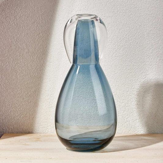 Steel blue night water set with a hand-blown glass carafe and matching tumbler lid, on a wooden surface.